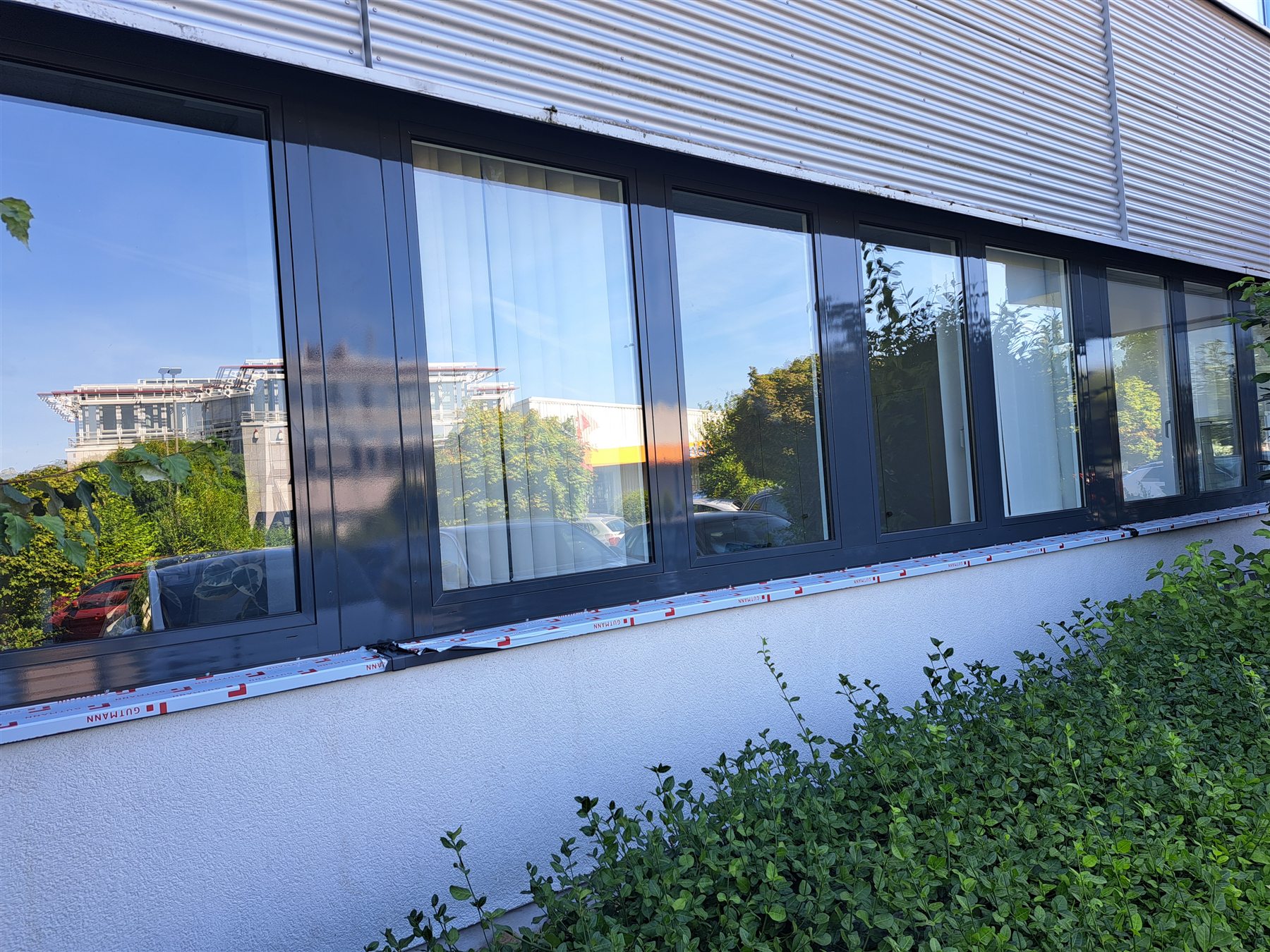 Lange Gewerbefensterfront mit folierten Rahmen in Anthrazit